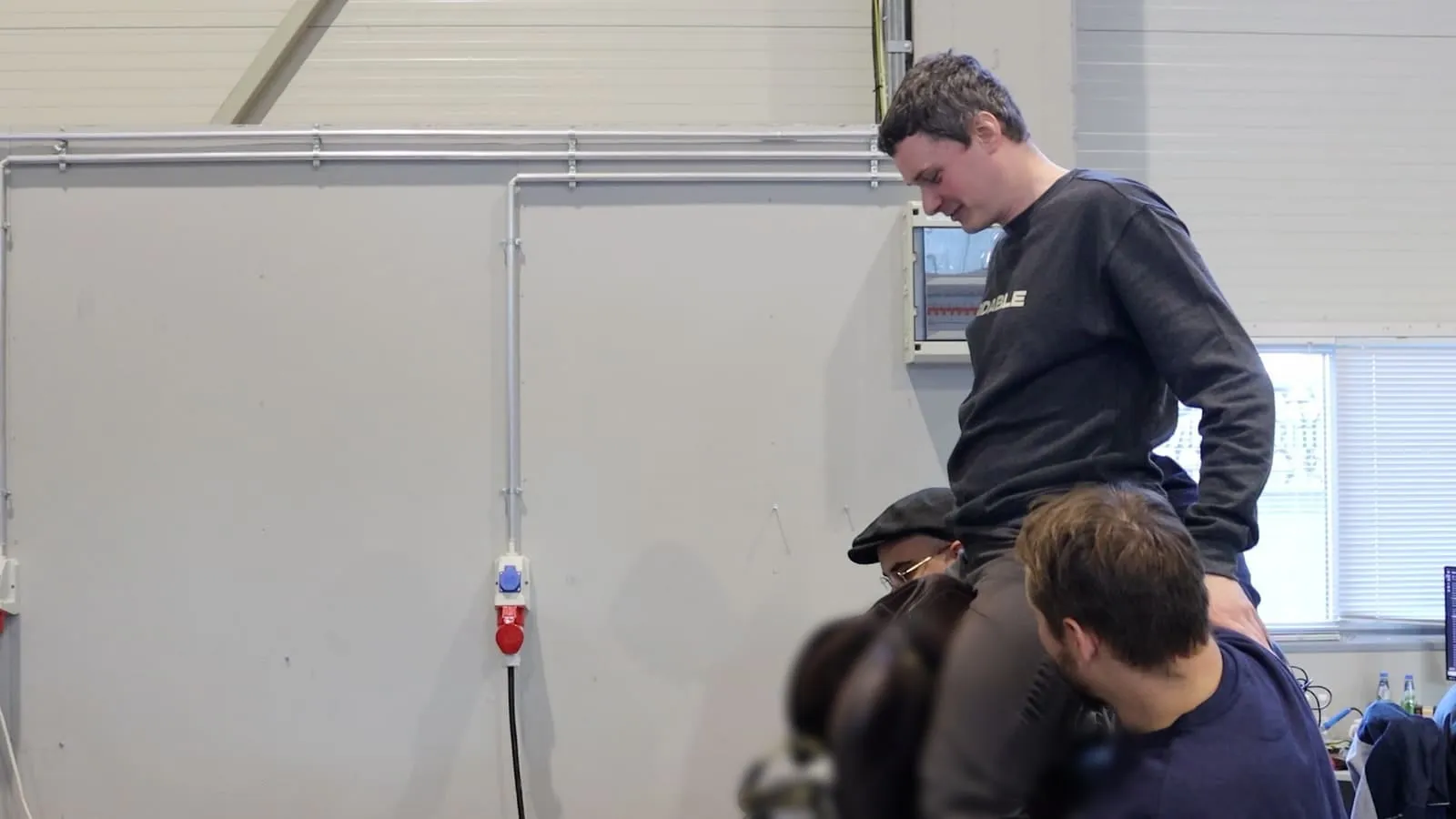 A rider sitting on the saddle rig in the workshop
